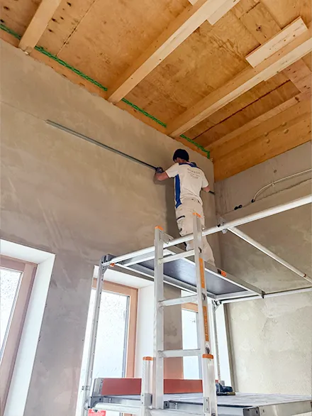 Mitarbeiter auf Leiter beim vermessen